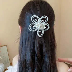 Vista dettagliata di un'elegante clip per capelli a fiore di perle su capelli scuri