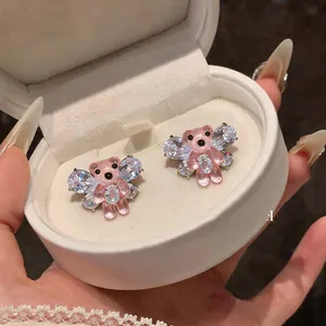 Primo piano di orecchini a forma di orso in resina rosa con ali di cristallo scintillanti