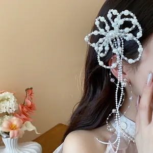 Primo piano di una forcina per capelli con fiori di perle e nappe in stile francese chic