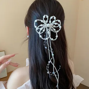 Dettaglio di un'elegante clip per capelli a fiore di perle con lunghe nappe sui capelli