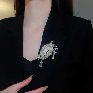 Detailed view of a vintage anatomical heart brooch with crystals on a black blazer.