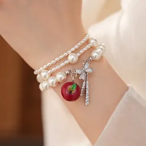 Elegante bracciale di perle multistrato con fiocco in zircone e ciondolo a mela rossa