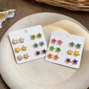 Detail showing multiple colorful star-shaped stud earrings on white display cards
