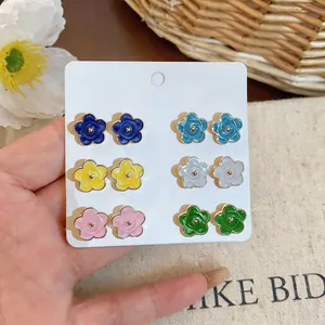 Close-up of colorful camellia flower stud earrings set in six vibrant and sweet shades