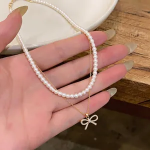 Collana di perle stile francese con ciondolo a fiocco dorato per donna elegante