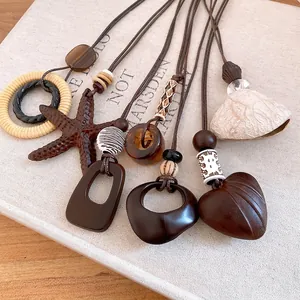 Collection of vintage resin and wood bead pendant necklaces with leather cords on book