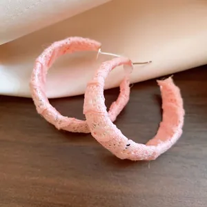 Dettaglio degli orecchini a cerchio a C avvolti in chiffon rosa con perni in argento