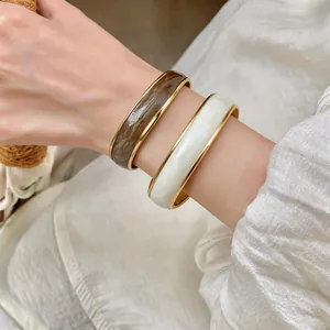 Primo piano di bracciali con trama marmorea e raffinati bordi in metallo dorato