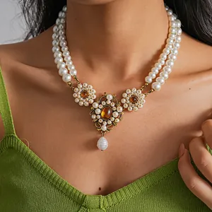 Detailed view of vintage double-layer pearl necklace with amber resin floral pendant