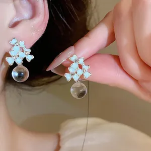 Detailed view of elegant French-style floral resin earrings with sparkling clear rhinestones