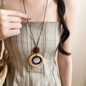 Close-up detail of a retro long necklace featuring wood beads and resin circular pendants
