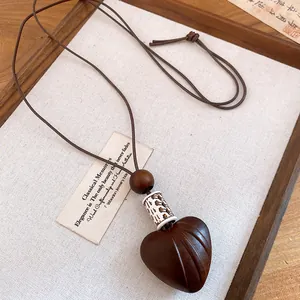 Detailed view of the vintage heart pendant necklace with rustic wooden bead and leather cord