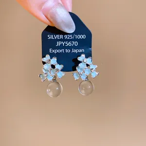 High-quality detail of elegant resin flower earrings with blue enamel and crystals