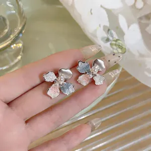 Detailed view of elegant flower stud earrings featuring colorful enamel petals and center pearls