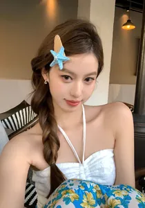 Nahaufnahme eines 3D-Haarclips in Seesternform mit Perle, getragen von einem asiatischen Model.