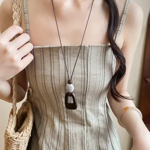Vintage style leather cord necklace with brown resin pendant and white bead detail