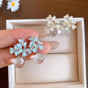 Close-up detail of French style resin flower stud earrings with a clear drop bead