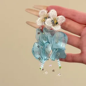 Close-up of blue chiffon flower tassel earrings with intricate bead decorations