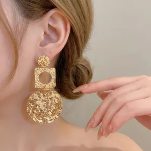 Fashionable 18k gold plated geometric wrinkled drop earrings worn by a model