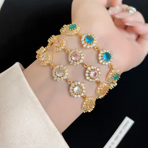 Détail des bracelets fleurs en zircon multicolore sur un poignet avec finition dorée