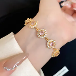 Gros plan d'un élégant bracelet en fleurs dorées avec zircons roses et cristaux