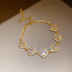 Gros plan d'un luxueux bracelet en or orné de zircons blancs très étincelants.