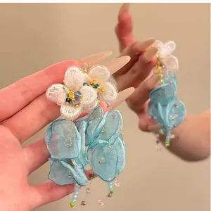 Close-up of sweet chiffon flower tassel earrings featuring blue petals and delicate beads