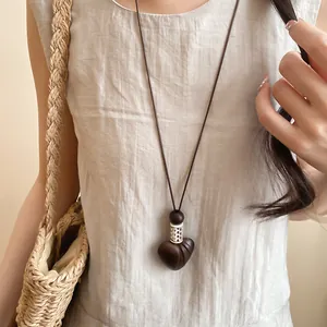 Detail of vintage heart pendant necklace with dark brown leather cord and silver accents