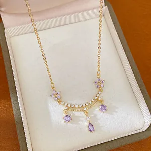 Makroaufnahme einer eleganten 18k vergoldeten Halskette mit lila Zirkonia-Blumen