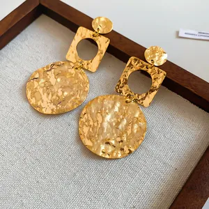 Close-up of 18k gold plated hammered geometric round earrings with wrinkled texture