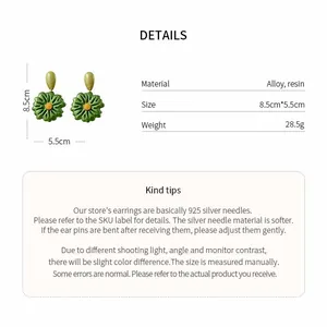 Dettaglio di orecchini a fiore in resina verde con specifiche tecniche di peso e misura.