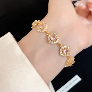 Gros plan d'un élégant bracelet doré orné de fleurs en zircone cubique rose brillant