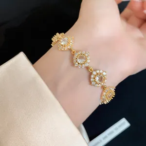 Détail macro du luxueux bracelet fleur doré avec incrustation de pierres de zircon