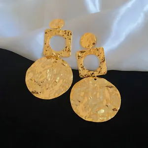 Detail of 18k gold plated hammered geometric drop earrings with crinkled texture