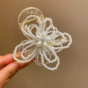 Detailed macro view of an elegant pearl-encrusted flower hair claw clip accessory