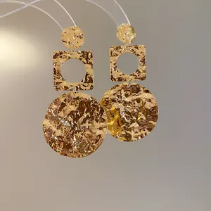 Macro view of 18k gold plated hammered earrings with wrinkled geometric design details