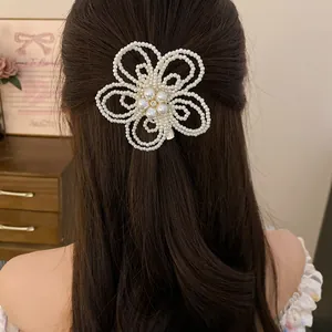 Elegant large pearl flower hair clip worn on long dark hair for a sophisticated look