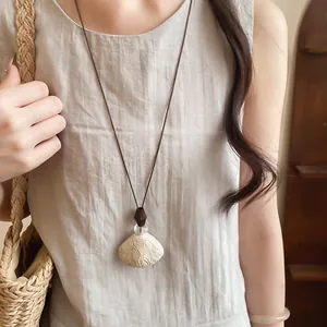Detail of vintage resin pendant necklace with brown cord and organic leaf textures