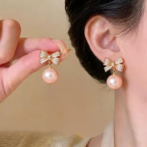 Elegante Schleifenohrringe mit Zirkoniasteinen und Pfirsichperlen im Retro-Look