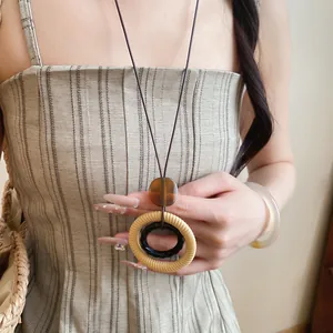 Detailed close-up showing the textures of retro resin and woven ring pendant on model
