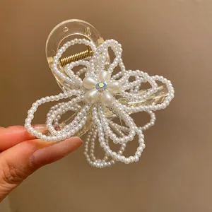 Elegant detail of a pearl flower hair claw clip featuring a shimmering iridescent center