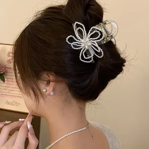 Detailed view of an elegant pearl flower hair claw clip worn in a beautiful hair bun