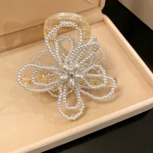 Close-up of an elegant pearl flower hair claw clip in a velvet box.