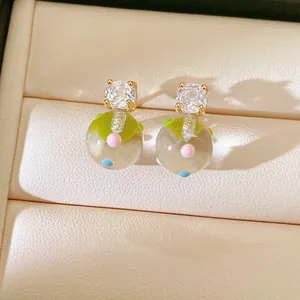 Close-up view of sweet forest style stud earrings with zircon and colorful glass ball