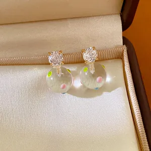 Close-up detail of 18k gold plated zirconia earrings featuring colorful dot glass balls