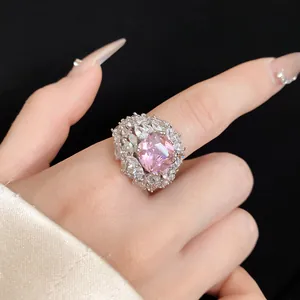 Close-up of elegant pink square zircon ring with cluster diamond halo design