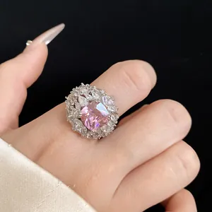 Close-up view of an elegant silver-toned ring with a large pink cushion-cut center stone.
