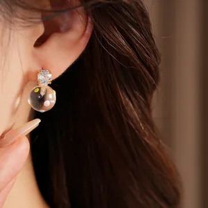 Detailed close-up of a sweet zircon stud earring with a clear colorful glass ball