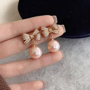 Elegante Ohrstecker mit Schleife in Roségold, rosa Perlen und funkelnden Zirkonia