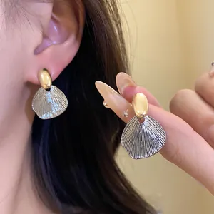 Vue détaillée en gros plan des boucles d'oreilles feuilles en finitions or et argent